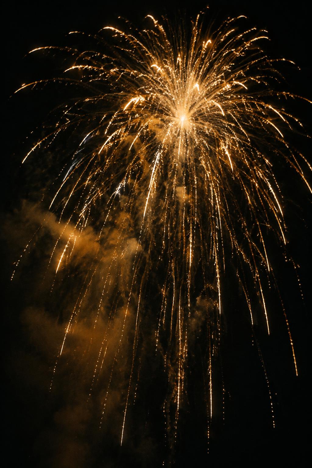 Goldenes Feuerwerk mit herabfallendem Funkenregen in der Nacht